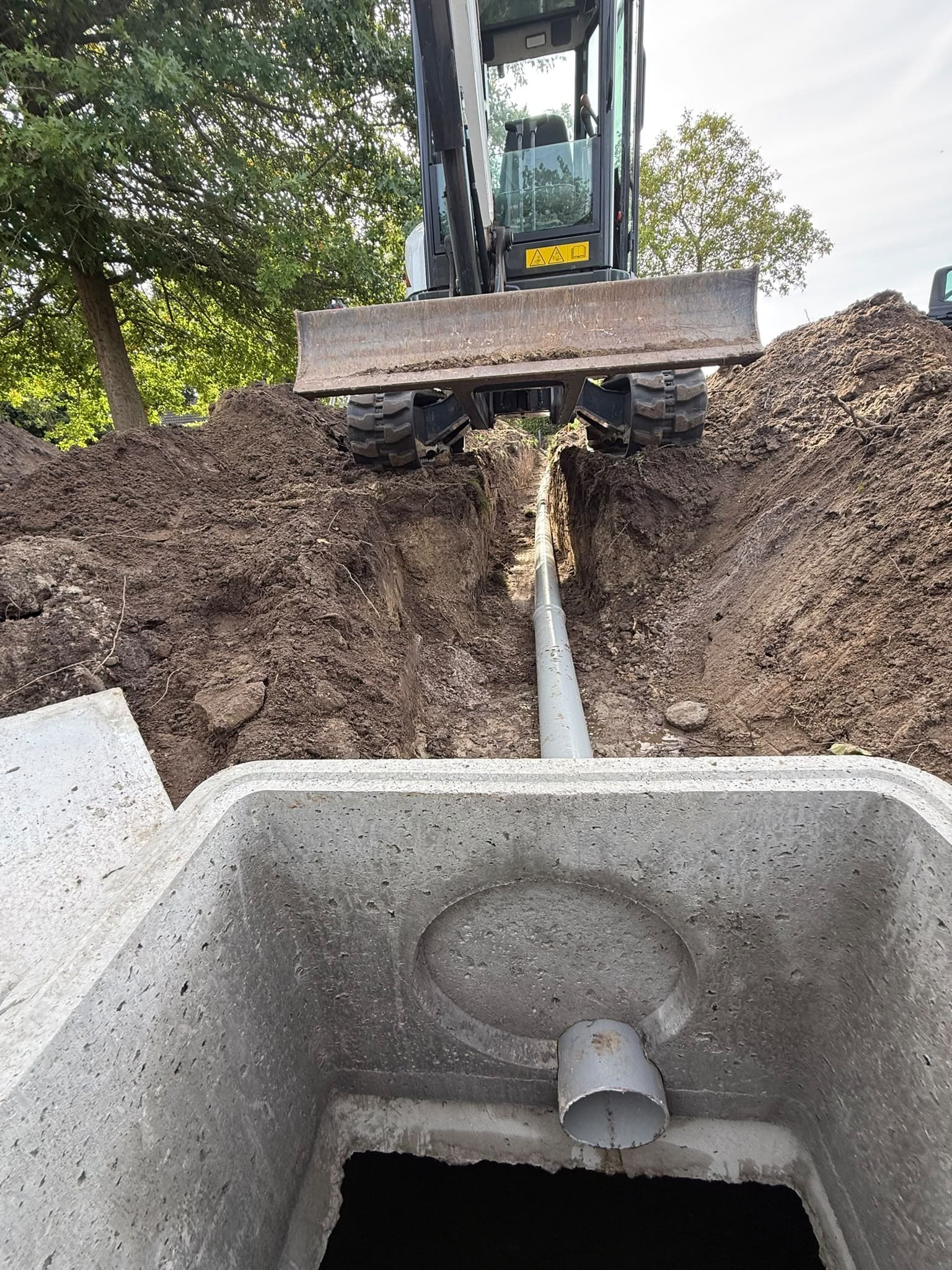 Aansluiting van een regenwaterput met minigraver