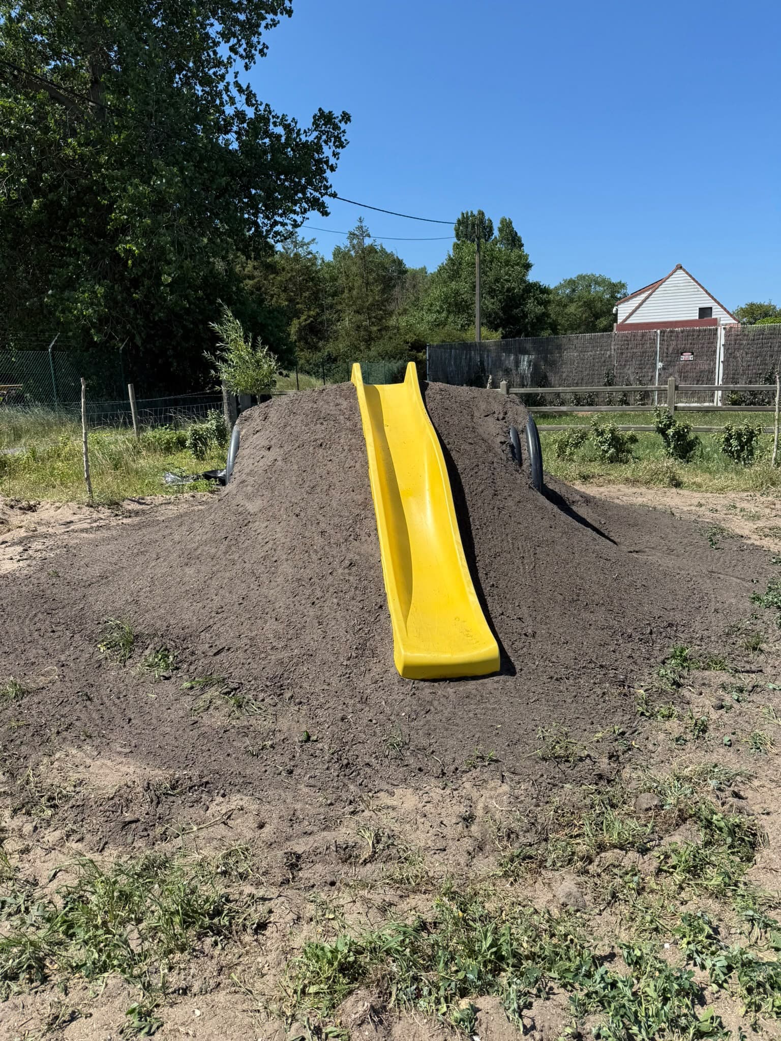 Speelheuvel met gele glijbaan, aangelegd door Croes Construct