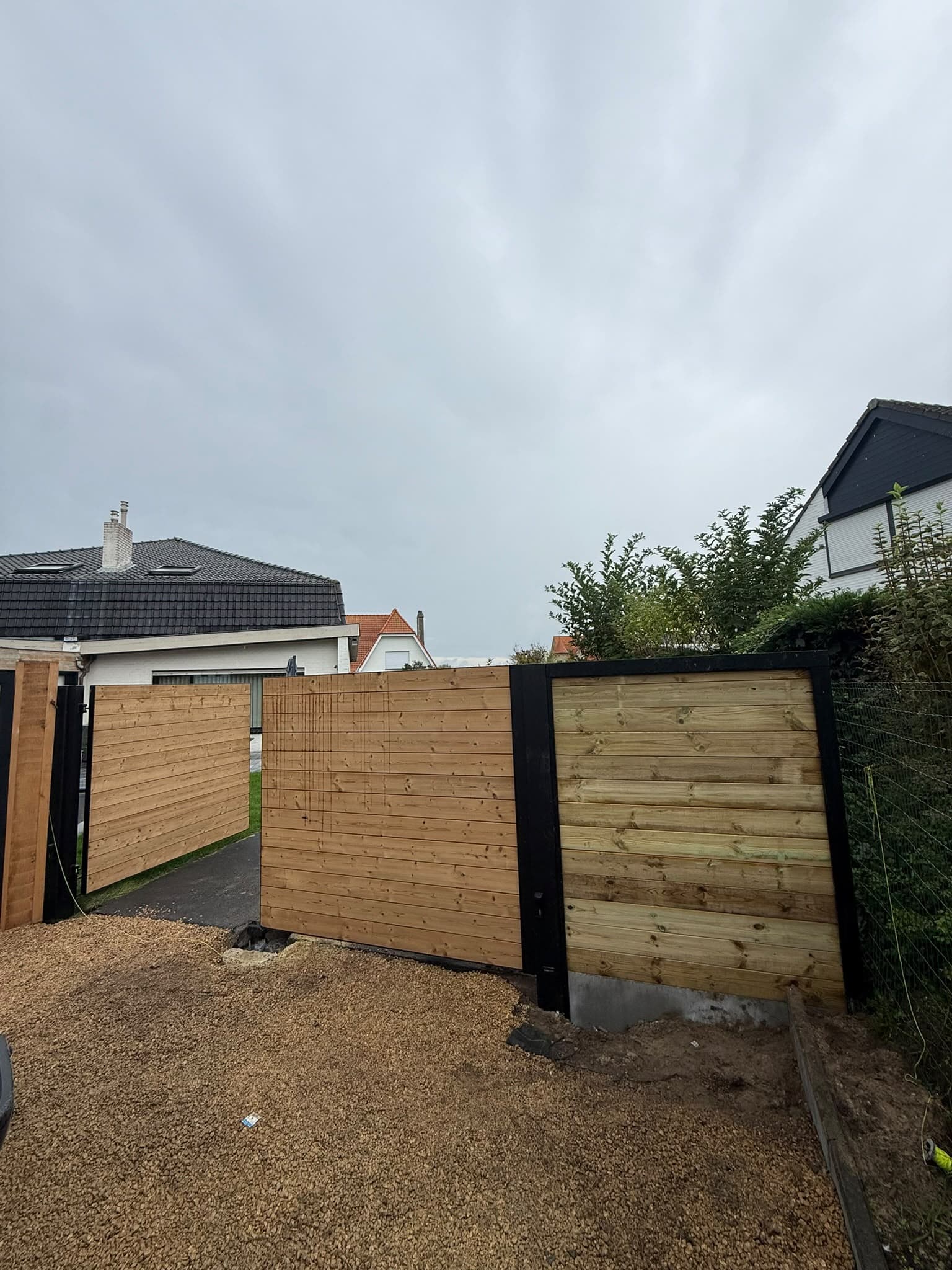 Houten omheining tussen zwarte palen