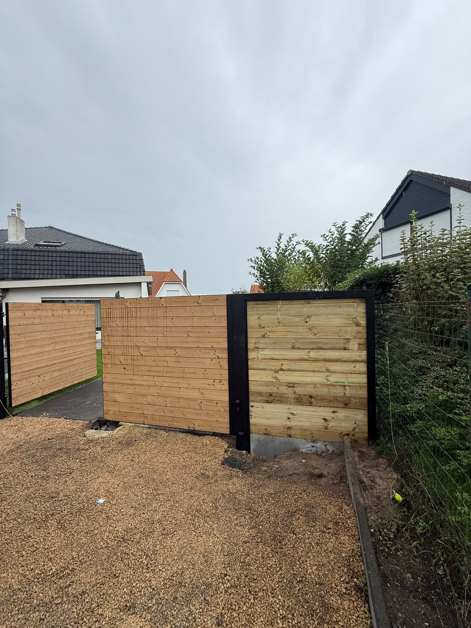 Houten omheining met zwarte palen, zijaanzicht