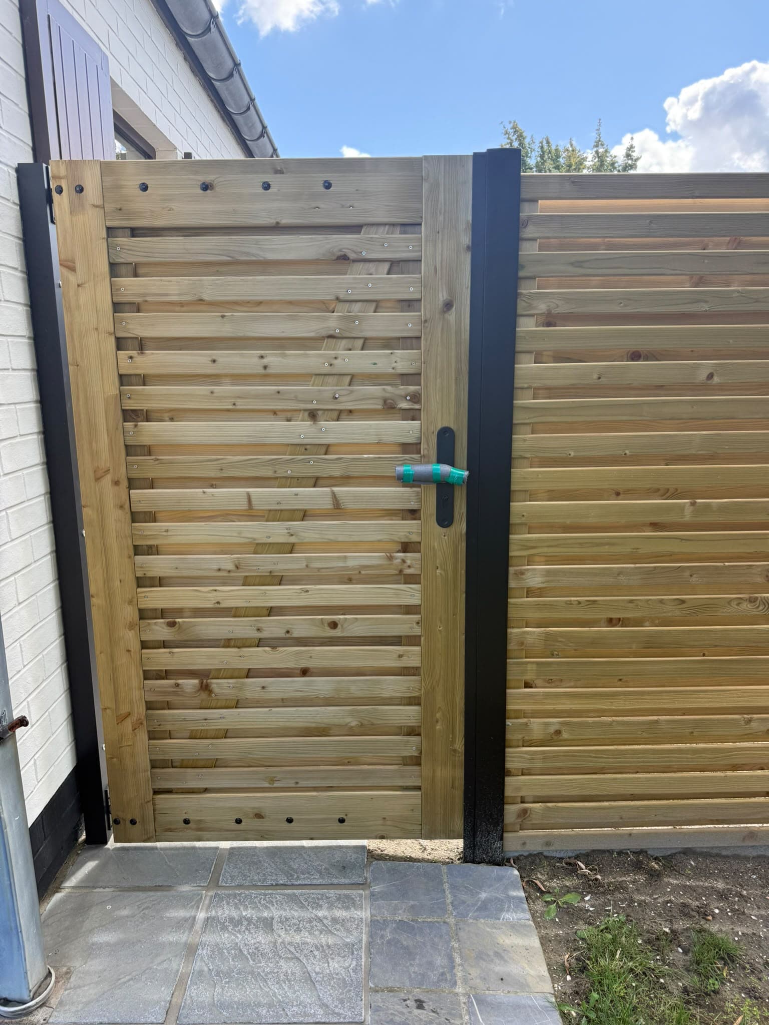 Houten tuinpoort in een zwart kader