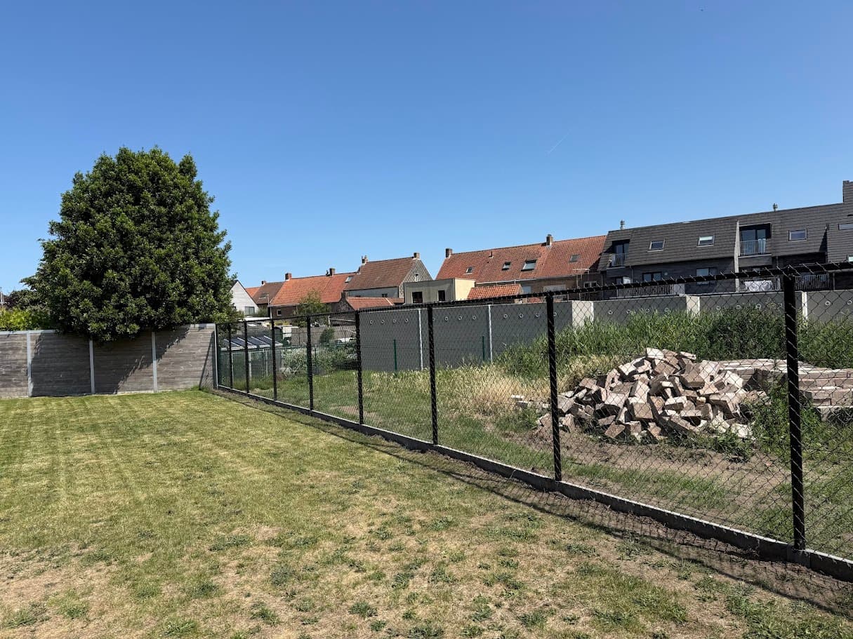 Zwarte draadafsluiting langs een gazon