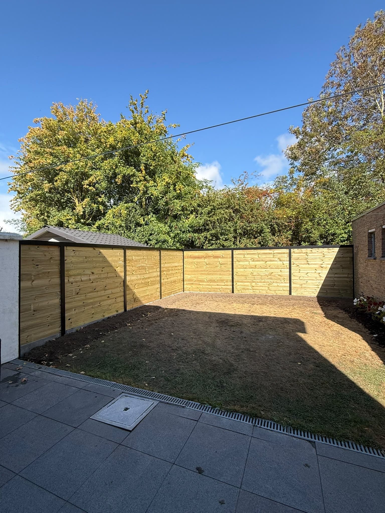 Houten omheining rond een tuin met terras